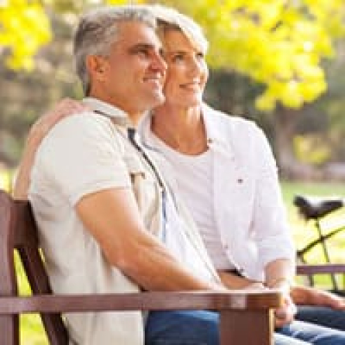 Happy mature couple enjoying outdoor chiropractic treatment in park.