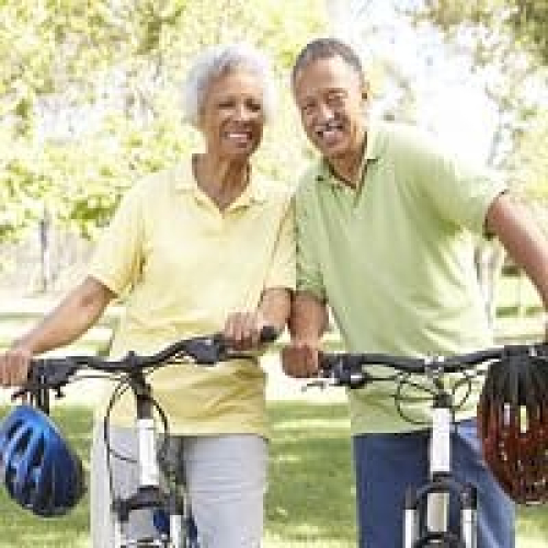 Elderly couple enjoying outdoor bike ride in park.